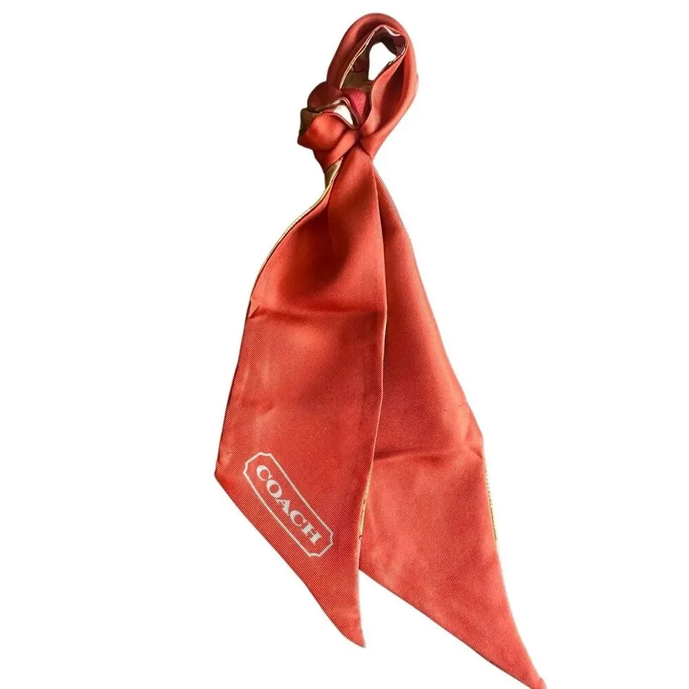 COACH silk twilly scarf orange poppy and tan signature Cs background
